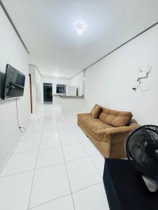 a living room with a couch and a tv at Casa Mobiliada Plus Gurupi in Gurupi