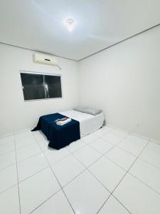 a white room with a bed and a tv at Casa Mobiliada Plus Gurupi in Gurupi