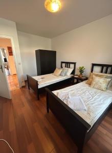 two beds in a room with wooden floors at Midtown Apartment Hannover in Hannover