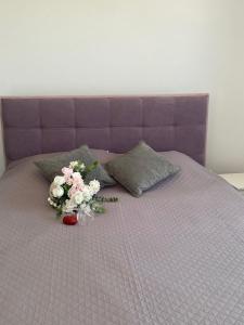 a purple bed with a bouquet of flowers on it at Olivia Suite in Pano Arodes +9 photos