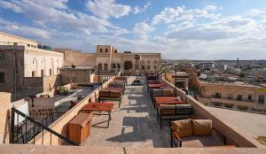 a row of chairs and tables on a balcony at Mons Masius Hotel Teras in Midyat