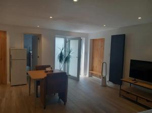 a living room with a table and a refrigerator at Kamer Zwijnaarde in Ghent