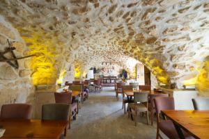 a restaurant with a stone wall and tables and chairs at Mons Masius Hotel Teras in Midyat