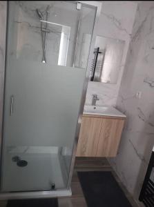 a white bathroom with a shower and a sink at Kamer Zwijnaarde in Ghent