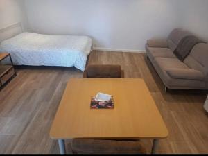 a living room with a table and a couch at Kamer Zwijnaarde in Ghent +4 photos
