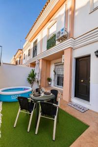 a patio with a table and chairs and a pool at Casa SOL y MAR junto a la PLAYA in Sanlúcar de Barrameda