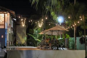 eine Terrasse mit Sonnenschirm, Tisch und Stühlen in der Unterkunft Hotel Vale Verde Coroa Vermelha in Santa Cruz Cabrália