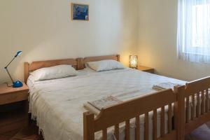 a bedroom with a large bed with white sheets and pillows at Garden Apartments Lustica in Radovici