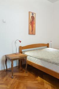 a bedroom with two beds and a table with a lamp at Garden Apartments Lustica in Radovici
