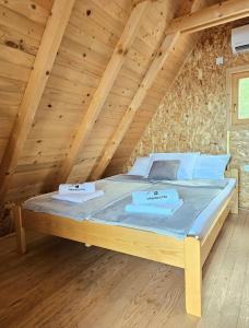 a bed in a room with a wooden ceiling at Vikendice Una i Andrea in Bileća