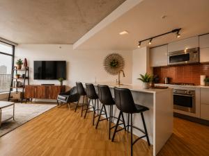 a kitchen with a bar with black stools at Historic Downtown Escape in Vancouver