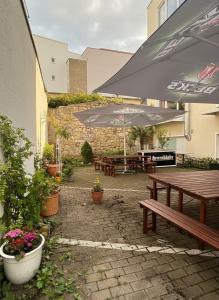 a patio with benches and tables with umbrellas at Midtown Apartment Hannover in Hannover