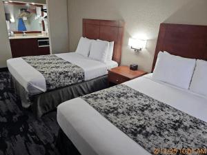 a hotel room with two beds and a table at Best Western Montis Inn in Saint Robert
