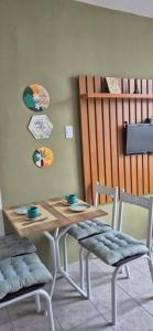 a dining room table with two chairs and a table with cups on it at Cantinho do Sol e Mar in São Vicente