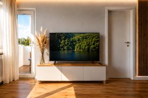 a living room with a flat screen tv on a white cabinet at Apartment Hannover - Langenhagen center 2 in Hannover
