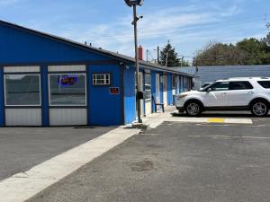 a white car parked in front of a blue building at Sunshine Motel in Yakima