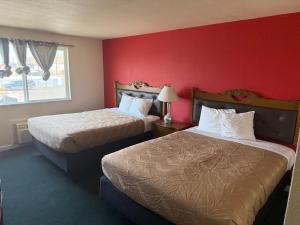 a hotel room with two beds and a red wall at Sunshine Motel in Yakima