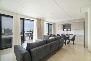 a living room with a couch and a dining room at Goudis Luxury Villas Lefkada Sea View & Private Pools in Tsoukalades