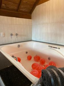 a bath tub with red balls in it at Chales Fazenda Cantinho do Selado in Monte Verde +54 photos