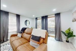 a living room with a brown couch and windows at Lake Luxe in Lake Ariel +150 photos