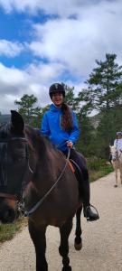 a woman riding a horse on a dirt road at Hotel Rural Rio Molinar - ADULTS ONLY in Ranera