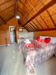 a bedroom with a bed with red roses on it at Chales Fazenda Cantinho do Selado in Monte Verde