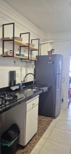 a kitchen with a sink and a refrigerator at Cantinho do Sol e Mar in São Vicente +28 photos