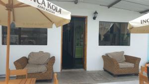 a patio with two chairs and an open door at casa posada cabaña paracas in Paracas