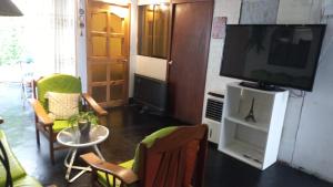 a living room with a television and a table and chairs at casa posada cabaña paracas in Paracas