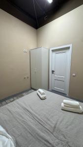 a room with a bed with two towels on it at Sky Tau Hostel in Almaty