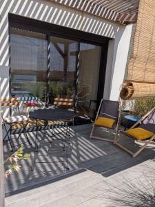 a patio with a table and chairs on a porch at Appartement bord de mer in Lampaul-Plouarzel