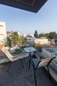 eine Terrasse mit Tisch und Stühlen auf einem Balkon in der Unterkunft Kallie in Volos