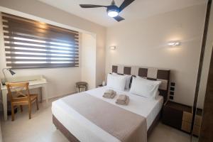 ein Schlafzimmer mit einem Bett, auf dem zwei Handtücher liegen in der Unterkunft Kallie in Volos