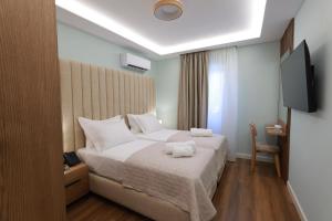 a bedroom with a bed with two towels on it at Voko by Uka Boutique Hotel in Tirana