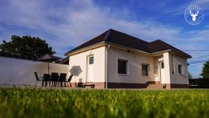 a small white house with a table and chairs at Rezéti vendégház in Pörböly