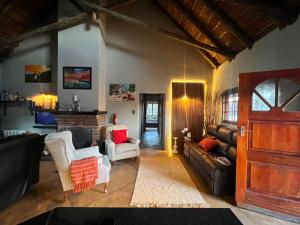 a living room with a couch and a fireplace at Kudu Plaas - Wildlife on your doorstep in Beestekraal
