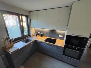 a kitchen with white cabinets and a wooden counter top at Apartmán Lesný Dvor in Martinske Hole