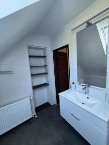 a white bathroom with a sink and a mirror at Apartmán Lesný Dvor in Martinske Hole +14 photos