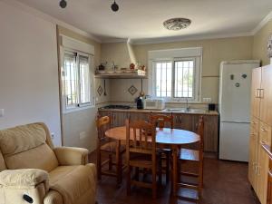 a kitchen with a table and a kitchen with a refrigerator at Casa Rural Villa María 2061 in Torrox