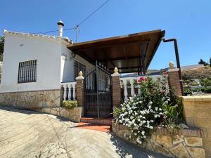 a house with a gate and flowers in front of it at Casa Rural Villa María 2061 in Torrox