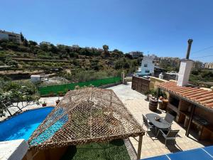 a patio with a table and a swimming pool at Casa Rural Villa María 2061 in Torrox