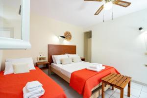 a bedroom with two beds with red sheets at Lemon Garden Apartments in Lygia