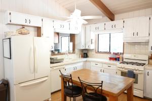 a kitchen with a table and a white refrigerator at Pine Hills Cabin in Julian in Julian