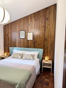 a bedroom with a blue bed and wooden wall at Cà di Grè - Camigliatello Silano in Camigliatello Silano