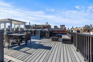 a deck with a table and chairs on a roof at 5 bdrm - Heated Indoor Pool - Roof Top Deck in Philadelphia