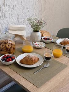 a table with a breakfast of croissants and orange juice at Cà di Grè - Camigliatello Silano in Camigliatello Silano