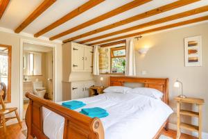a bedroom with a large white bed with blue towels on it at 2 Bed in Bridport oc-dc111 in Chideock