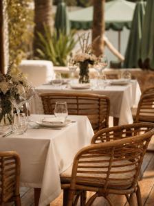 a table with white tables and chairs with wine glasses at Casa Lalla Hotel Rural in Douar Aguergour +4 photos