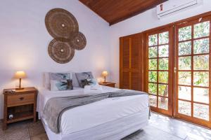 a bedroom with a large white bed and windows at Pousada Vereda da Serra in Pirenópolis +189 photos