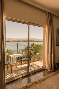 a room with a balcony with a view of the water at Casa Lalla Hotel Rural in Douar Aguergour